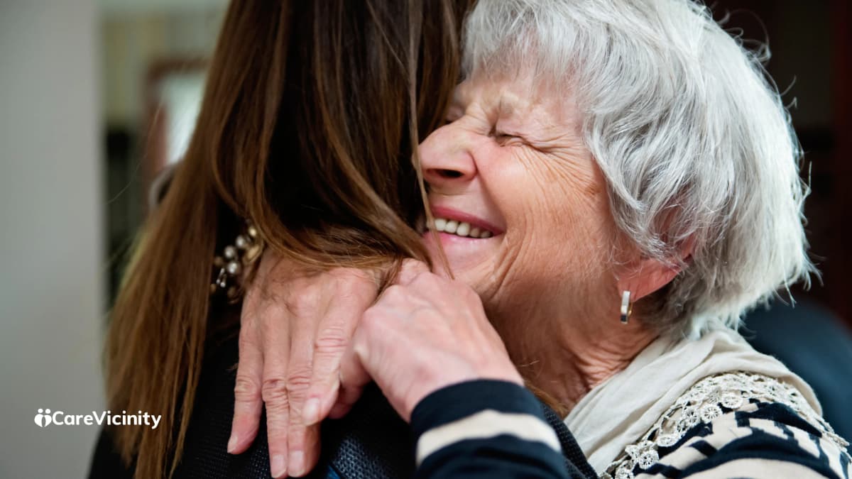 Support worker and older client sharing a conversation over tea at home