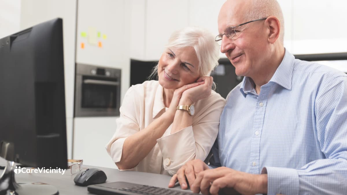 Older couple looking at a desktop computer together at home