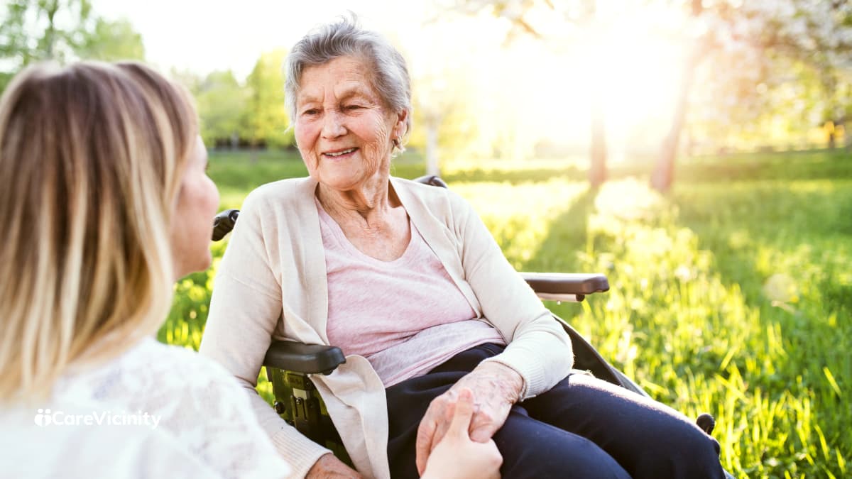 Support worker talking with an older client while helping with tasks in her home