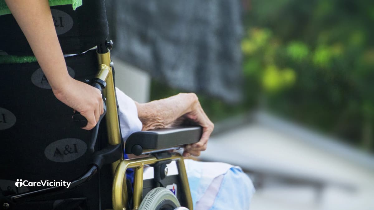 Older woman at home with her daughter and a paid support worker