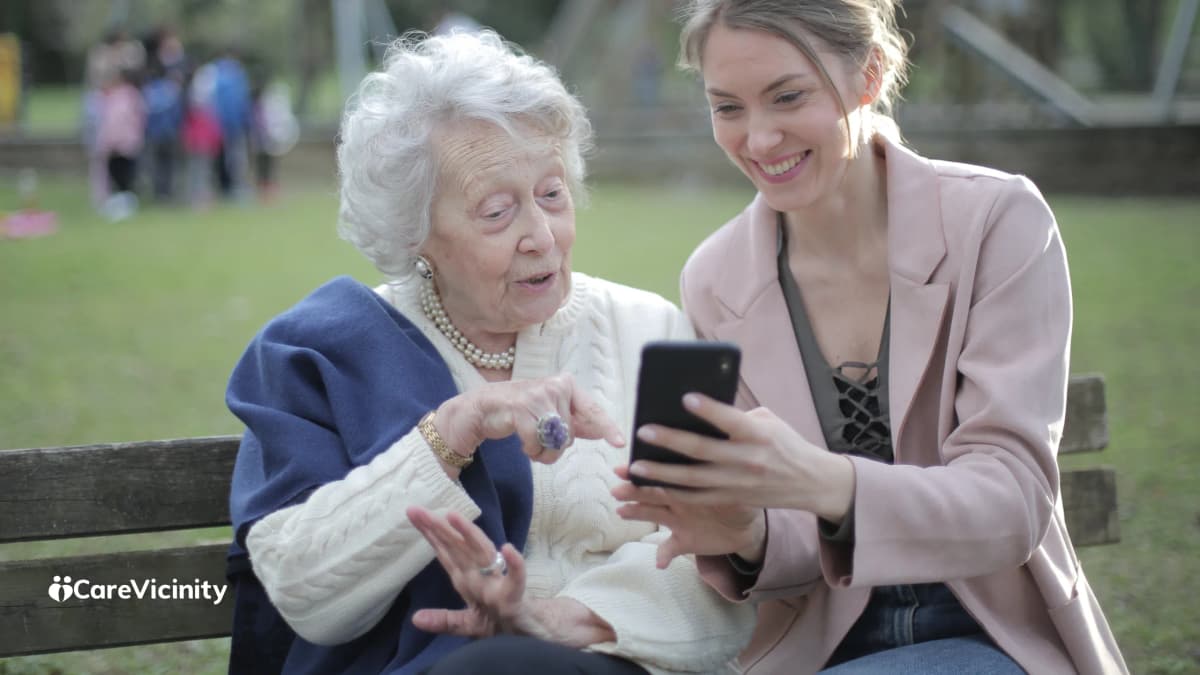 Older man reviewing information on his phone in a park