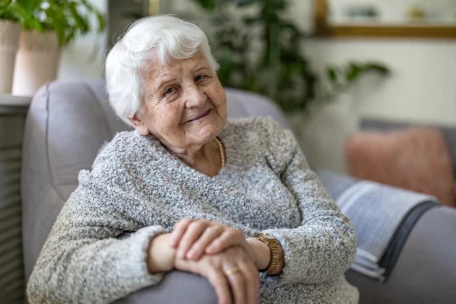 Older woman sitting comfortably in an armchair at home