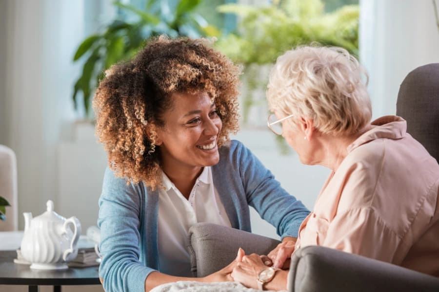 Support worker sitting at a table with two older women