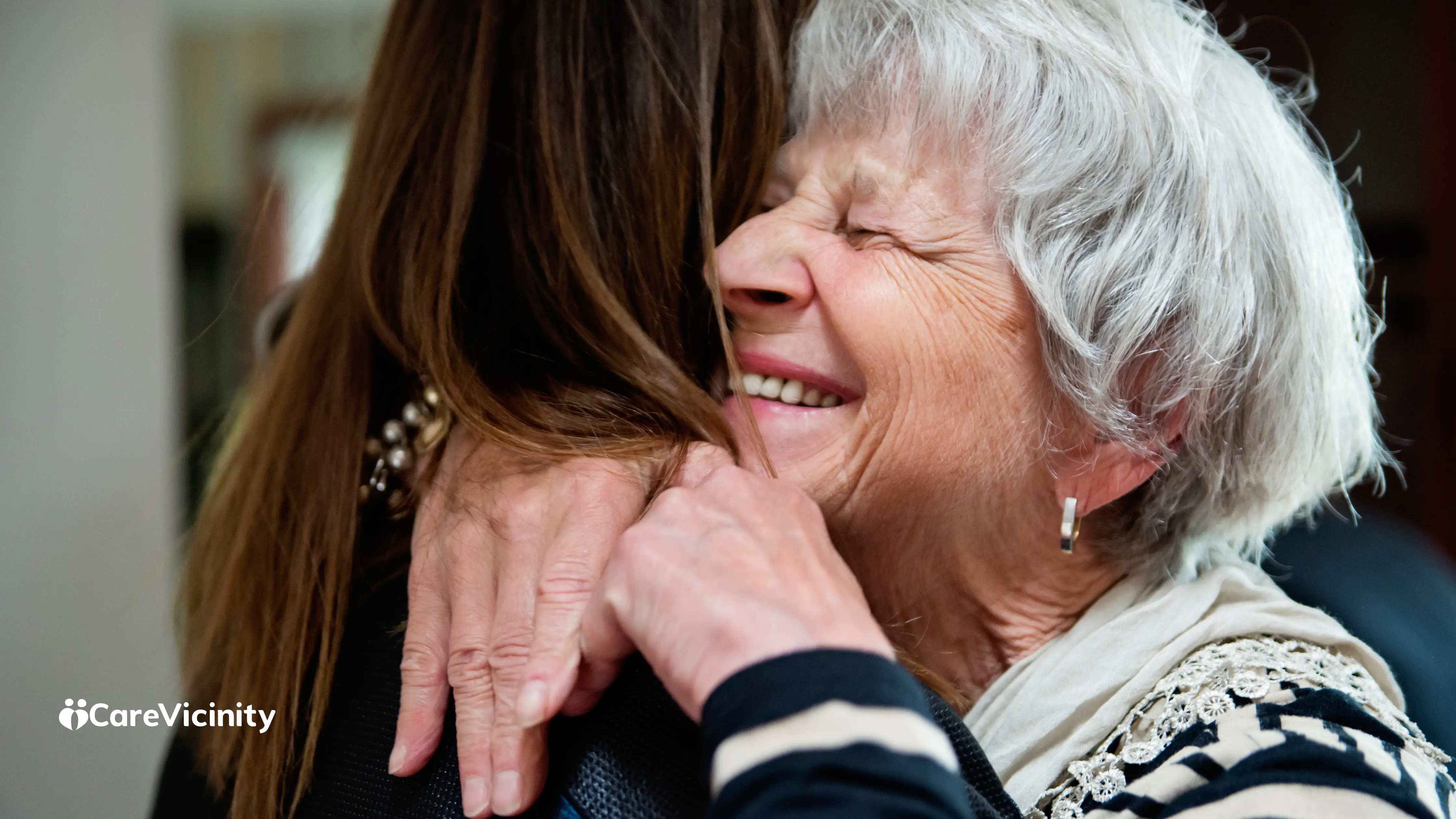 Support worker and older client sharing a conversation over tea at home