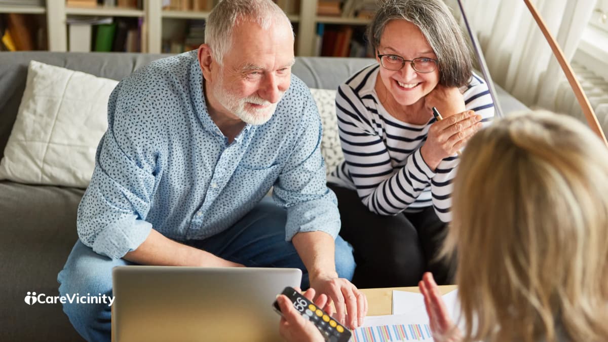 Coordinator reviewing a support worker agreement with a client and family member on a laptop