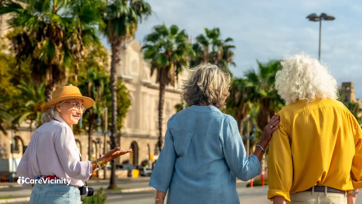 Three older women chatting together outdoors, a community and social-support scene