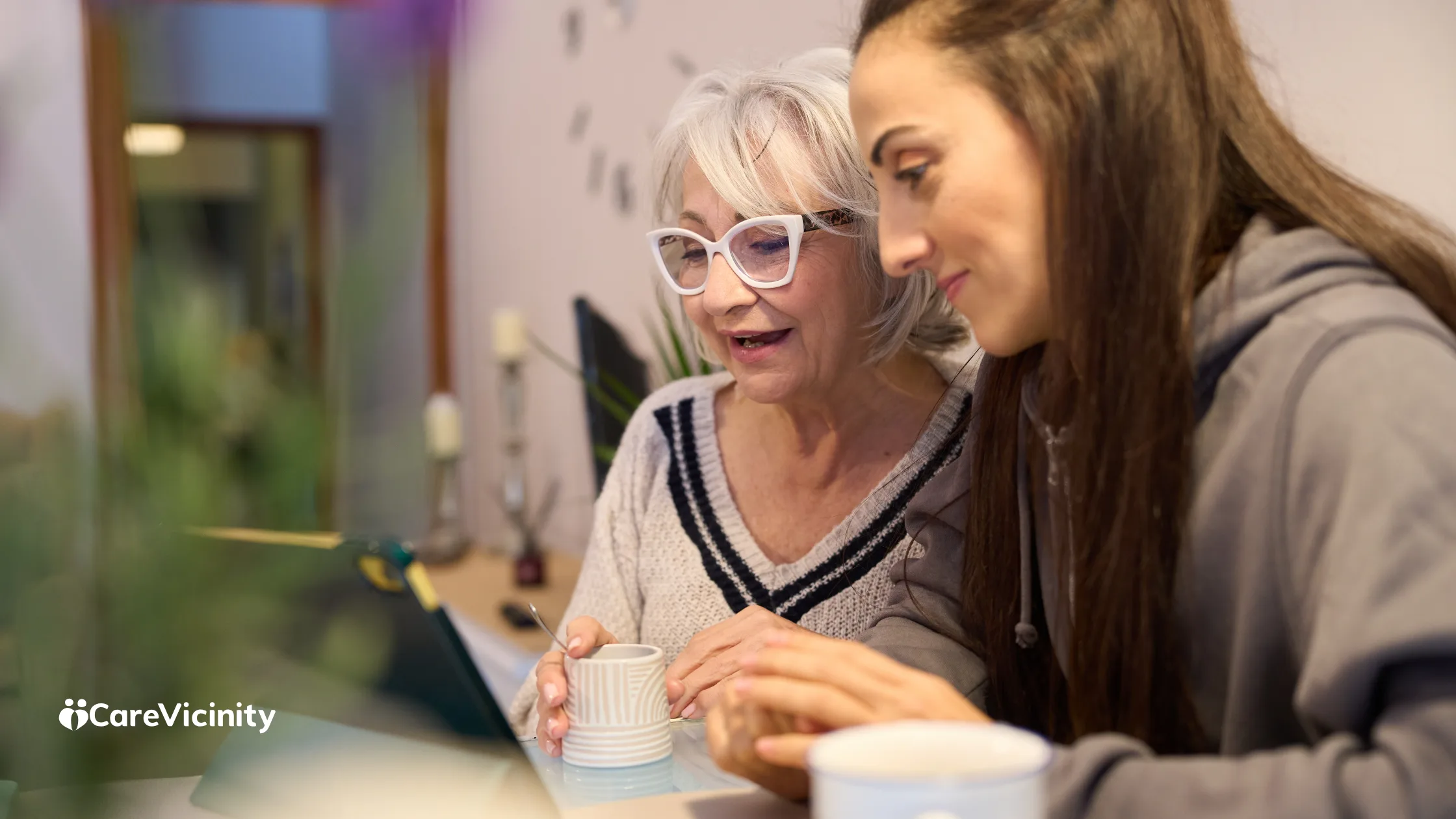 Coordinator and family member reviewing something together on a laptop over coffee